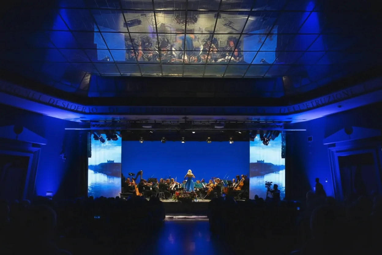 Concerti — orchestra Ars Armonica con videoproiezioni e luci blu sotto il soffitto in vetrate della sala Oggioni, scenografia digitale e light design per spettacoli dal vivo, SUONO E LUCE