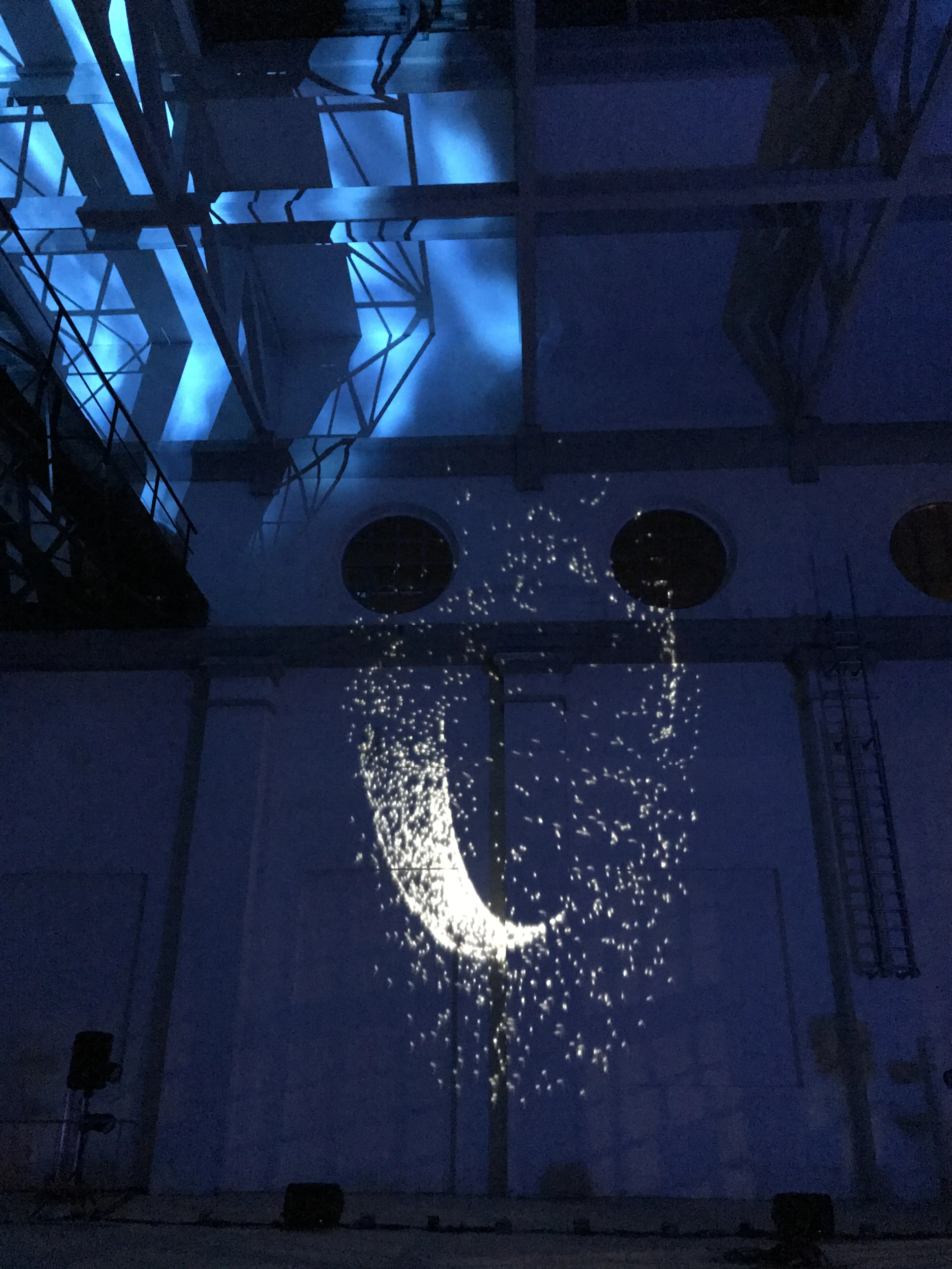 Scia di cometa proiettata sulla parete industriale della ex centrale termoelettrica di Daste e Spalenga — scenografia digitale generata dal suono in tempo reale, Danza Liquida SUONO E LUCE