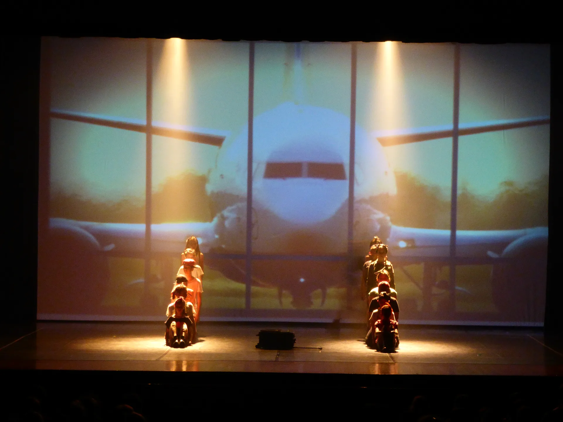Danzatrici con valigia e proiezione di aereo visto dalla vetrata dell'aeroporto — scenografia digitale per spettacolo di danza, SUONO E LUCE