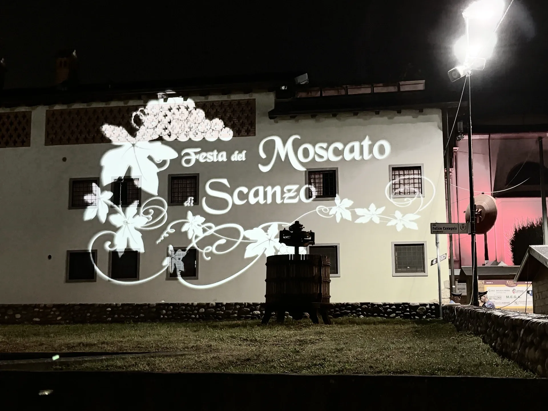 Maxiproiezione 'Festa del Moscato di Scanzo' su facciata con torchio antico in primo piano — SUONO E LUCE